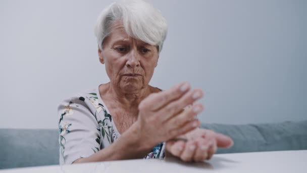 Bezorgde volwassen grijze vrouw die munten telt. Laag pensioenconcept — Stockvideo