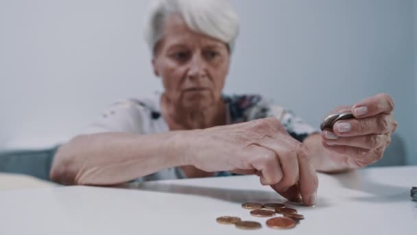 Bezorgde volwassen grijze vrouw die munten telt. Laag pensioenconcept — Stockvideo