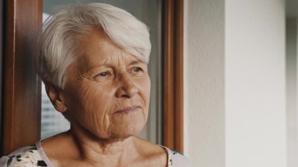 Портрет пожилой седой женщины, смотрящей вдаль — стоковое видео