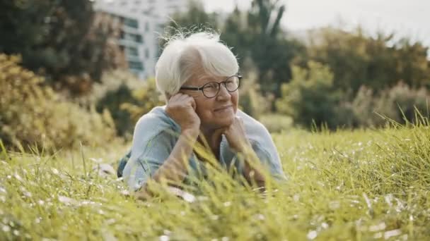 Senior důchodce žena těší slunný podzimní den v parku — Stock video