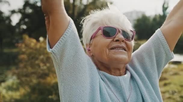 Portret van oudere vrouw met roze zonnebril oefenen in de natuur — Stockvideo