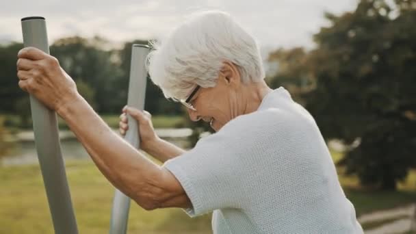 Stará žena cvičení v a venkovní tělocvična. Zpomalený pohyb — Stock video