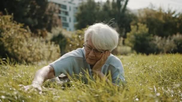 Femme mûre allongée sur la pelouse. Reconcordance avec le concept de nature — Video