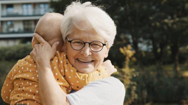 Mutlu büyükanne torununu doğada kucaklıyor. Aile bağları ve duygular