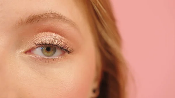 Close up, green eye of caucasian young woman. isolated on pink background — Stock Photo, Image