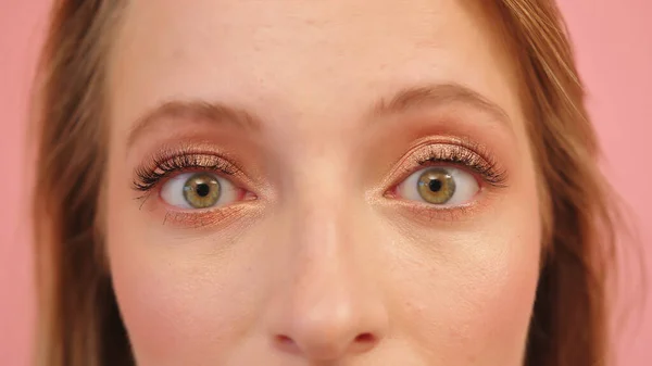 Макро знімок наляканої здивованої зеленої жінки очі ізольовані на рожевому фоні — стокове фото