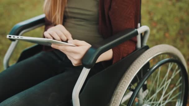 Jonge gehandicapte vrouw die buiten tabletten gebruikt. Sluiten. — Stockvideo