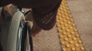 Yaklaş, tekerlekli sandalyenin direksiyonunu tutan genç kadın.. 