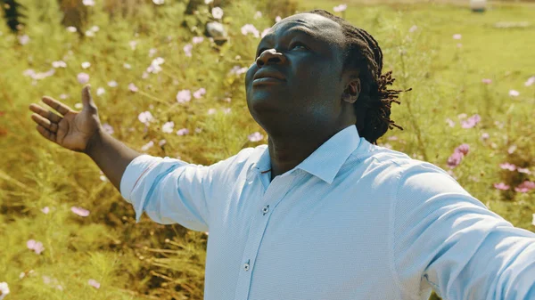 Hombre africano feliz con las manos extendidas disfrutando de la hermosa naturaleza en el prado o granja —  Fotos de Stock