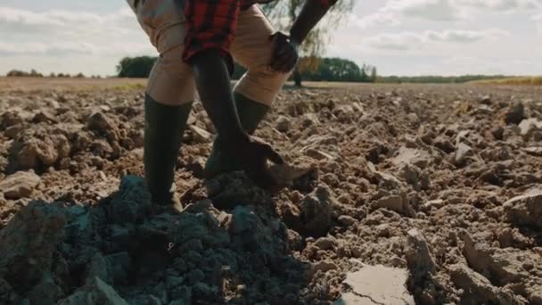 Agricultor negro africano recolhendo solo de terras cultivadas — Vídeo de Stock