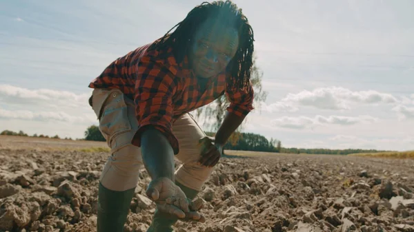 Agricultor negro africano recogiendo tierra de tierras aradas —  Fotos de Stock