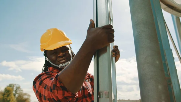 Afrikai fekete ember mérnök mászik a leders of the silio rendszer — Stock Fotó
