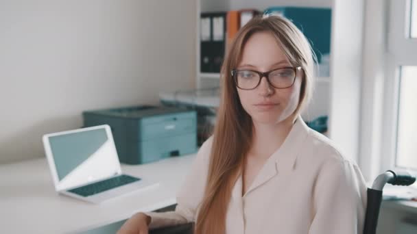 Ritratto di giovane donna disabile in ufficio sorridente verso la macchina fotografica — Video Stock