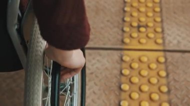 Yaklaş, tekerlekli sandalyenin direksiyonunu tutan genç kadının eli.. 