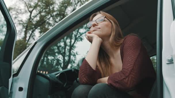 Giovane donna caucasica autista con auto aperte porta guardando la distanza — Video Stock