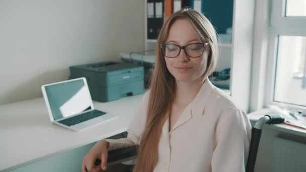 Ritratto di giovane donna disabile in ufficio sorridente verso la macchina fotografica — Video Stock