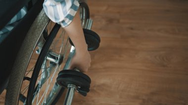 Tekerlekli sandalyede oturan genç bir kadının ağırlık kaldırışına yakından bakın.