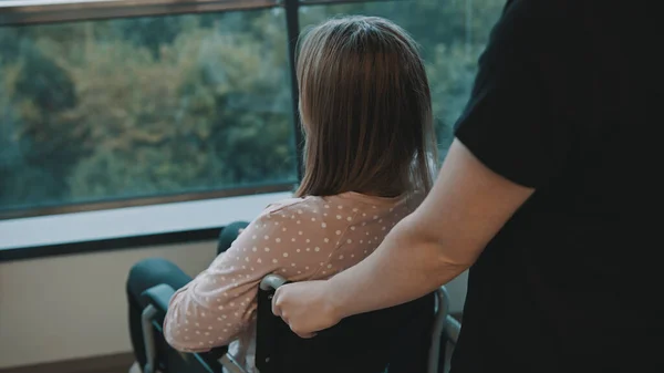 Pflegerin und junge Frau im Rollstuhl auf dem Balkon — Stockfoto