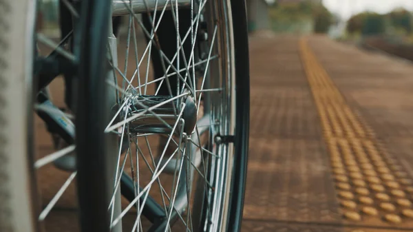 Ángulo bajo, primer plano de las ruedas de la silla de ruedas en la estación de tren — Foto de Stock