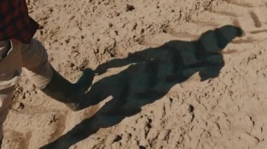Afrikalı çiftçi botlarıyla toprak üzerinde yürüyor. Atışı izle