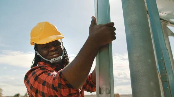 Afrikai fekete ember mérnök mászik a leders of the silio rendszer — Stock Fotó
