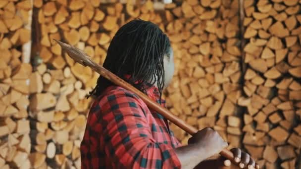 African lumberjack in the store with stacked logs for winter — Stock Video