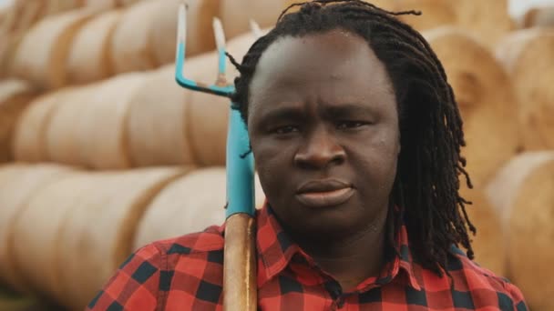 Πορτρέτο του νεαρού αφρικανού αγρότη με δίκρανο στον ώμο του — Αρχείο Βίντεο