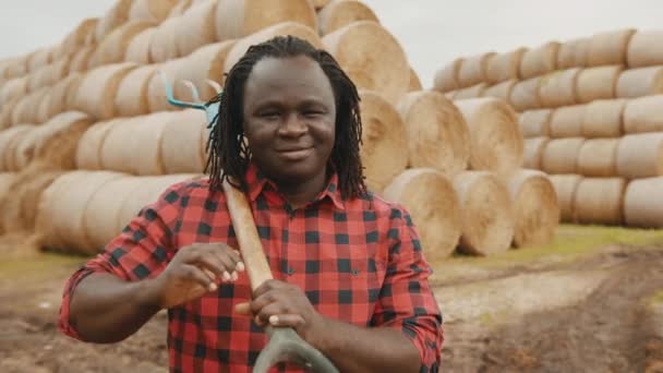 Portrait of young african farmer with pitchfork over his shoulder, thumb up — Stock Video