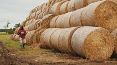 Genç Afrikalı bir adam, saman yığınının önünde tablet üzerinde çalışan bir çiftçi. Akıllı tarım kavramı, geniş açı
