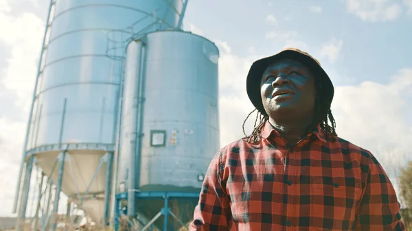 Joven granjero africano guapo parado frente al sistema de silos —  Fotos de Stock