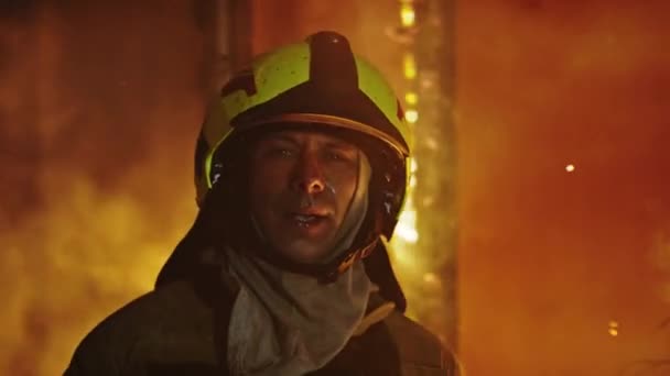 Retrato de un bombero cansado frente a la casa en llamas. Movimiento lento — Vídeos de Stock