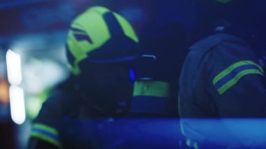 İki itfaiyeci su hortumuyla yangını söndürüyor.