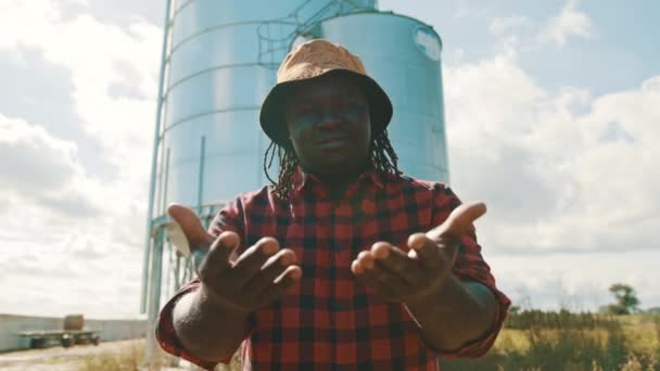 Un joven agricultor africano en el sistema de silos delanteros. me a ti gesto de mano — Vídeos de Stock