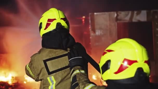 Feuerwehrmann löscht Brand mit dem Schlauch Brennendes Haus bei Feuerwehrübung — Stockvideo