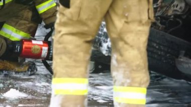 İtfaiyeci, kapana kısılmış kurbanı arabadan çıkarmak için hayat pençesi kullanıyor.