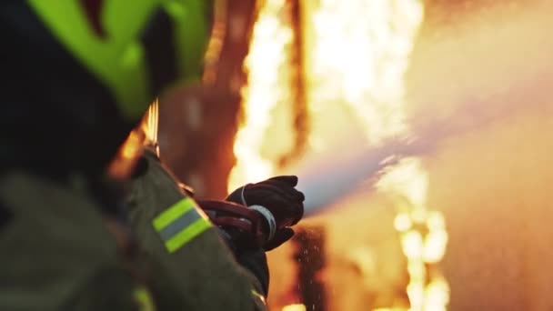 Los bomberos apagan el fuego con la manguera. Taladro de incendio de la casa en llamas — Vídeos de Stock