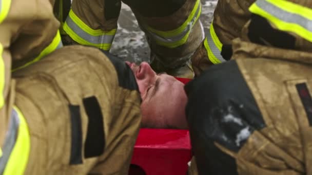 Feuerwehrleute heben verletzten Mann auf. Rettung nach Autounfall — Stockvideo