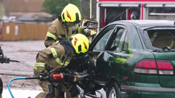 Brandweerlieden met behulp van kaken van het leven te bevrijden gevangen slachtoffer uit de auto — Stockvideo