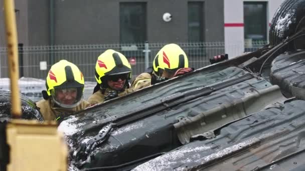 Bomberos girando el coche destrozado después de extinguido fuego — Vídeos de Stock