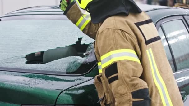 Bombero beraking vidrio en la ventana del coche sacar víctima atrapada del coche — Vídeos de Stock