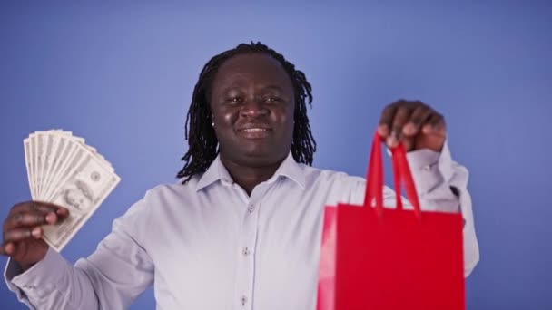 Αφρικανός που κρατάει κόκκινη τσάντα και χρήματα. Ώρα για ψώνια — Αρχείο Βίντεο