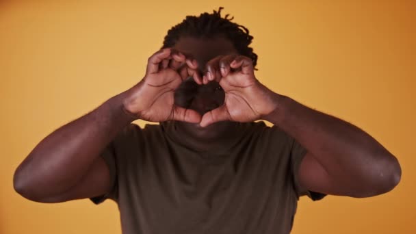 Afrikaanse man maakt hart vorm met zijn handen, close up. — Stockvideo