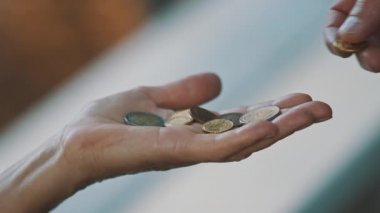 Yaklaş, erkek eli yaşlı evsiz kadına bozuk para veriyor. Hayırseverlik ve destek kavramı