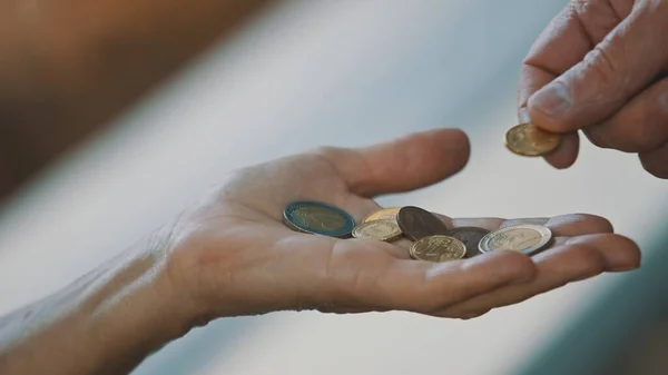 De cerca, mano de hombre dando monedas a anciana sin hogar. Concepto de caridad y apoyo — Foto de Stock