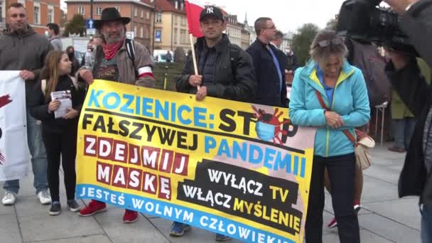 Варшава, Польша 10.10.2020 - Марш за свободу антиковидов - протестант с демоническим текстовым баннером — стоковое видео
