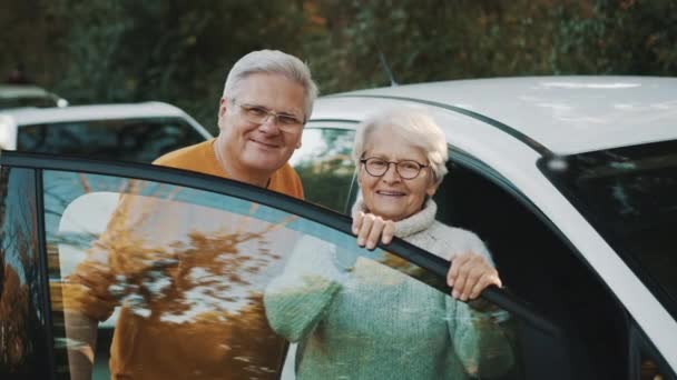 Seniorenpaar kaufte neues Auto. In der Nähe der Tür stehen und lächeln — Stockvideo