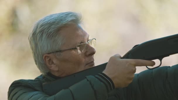 Homem de cabelos grisalhos idoso com uma arma nas mãos. Temporada de caça — Vídeo de Stock