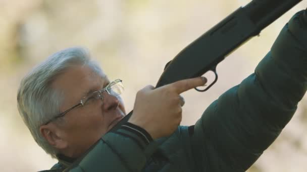 Oudere grijze man met een pistool in zijn handen. Jachtseizoen — Stockvideo