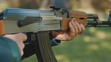 Yaşlı, gri saçlı, elinde silah tutan bir adam. Savaş ya da devrim kavramı