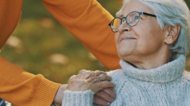 Ormanda romantik bir sonbahar günü geçiren yaşlı çift. Ağaca sarılmak ve gülümsemek
